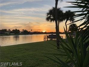 Dock area featuring a water view and a lawn