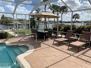 Swimming pool featuring a lanai, a patio area, a sunroom, and a water view