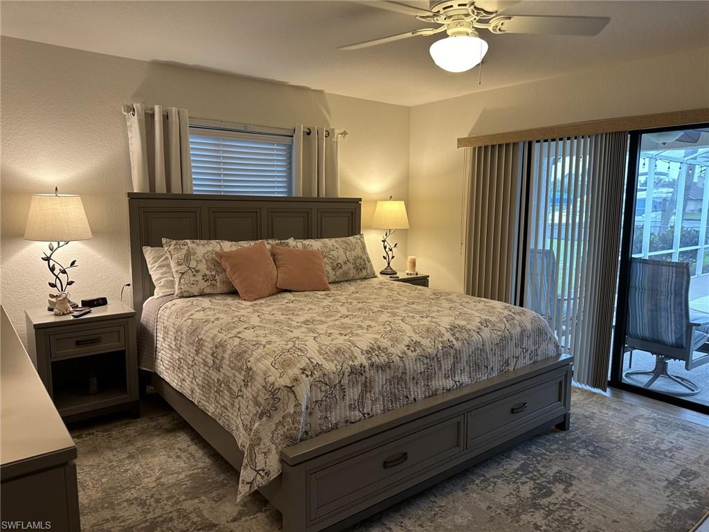 Bedroom with access to exterior, a ceiling fan, and a textured wall