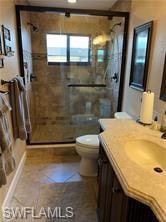 Full bathroom with vanity, a stall shower, and tile patterned flooring