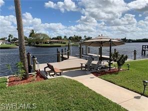 Dock with a water view, a yard, and boat lift
