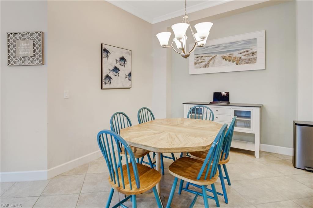 Tiled dining area with ornamental molding and a chandelier