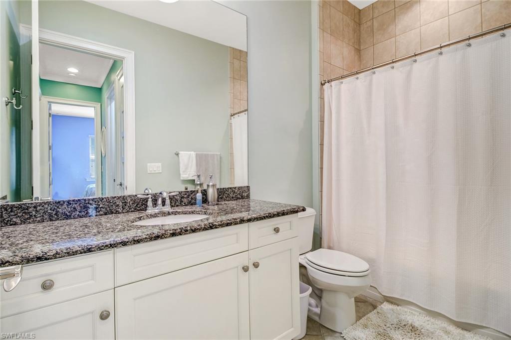 Bathroom featuring tile patterned flooring, vanity, toilet, and a shower with shower curtain