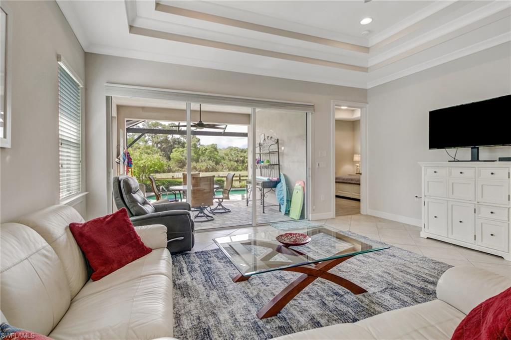 Living room with ornamental molding and light tile patterned floors