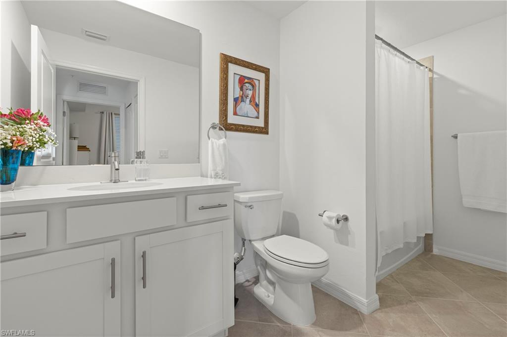 Bathroom with vanity, shower / bath combo, and light tile patterned floors