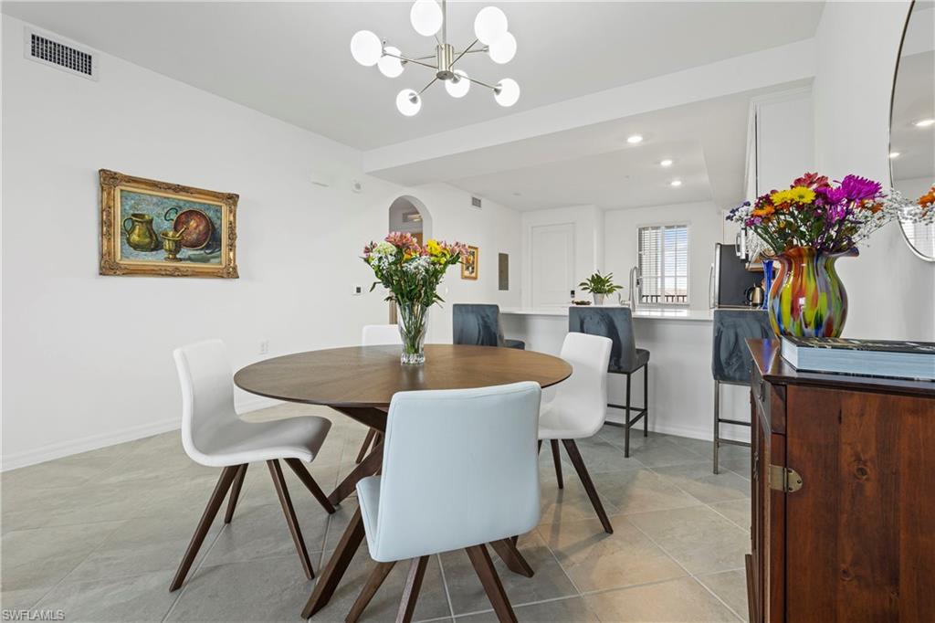 Dining room with recessed lighting, a chandelier, light tile patterned floors, and arched walkways