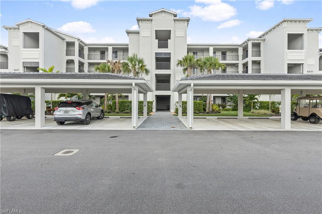 View of apartment building / complex with covered parking
