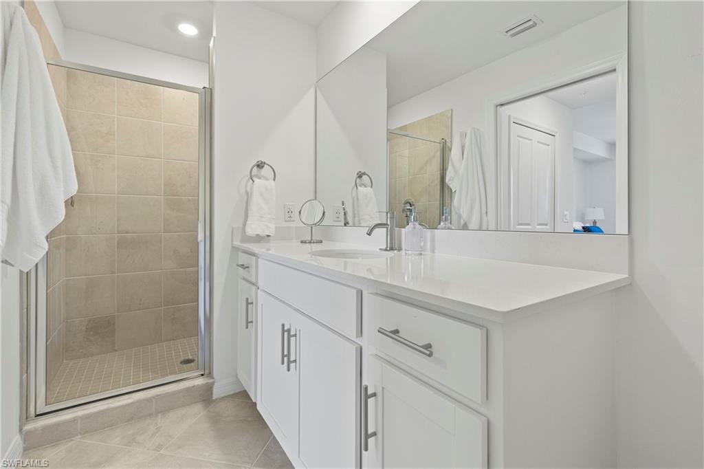Full bathroom featuring vanity, a shower stall, light tile patterned floors, and recessed lighting