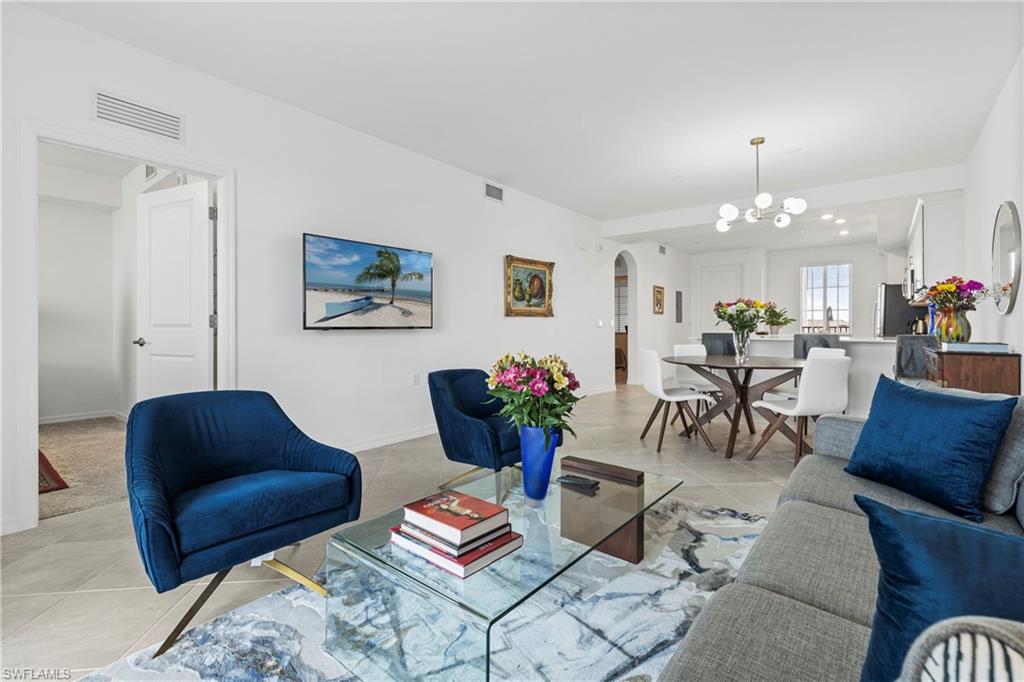 Living area featuring arched walkways and tile patterned floors