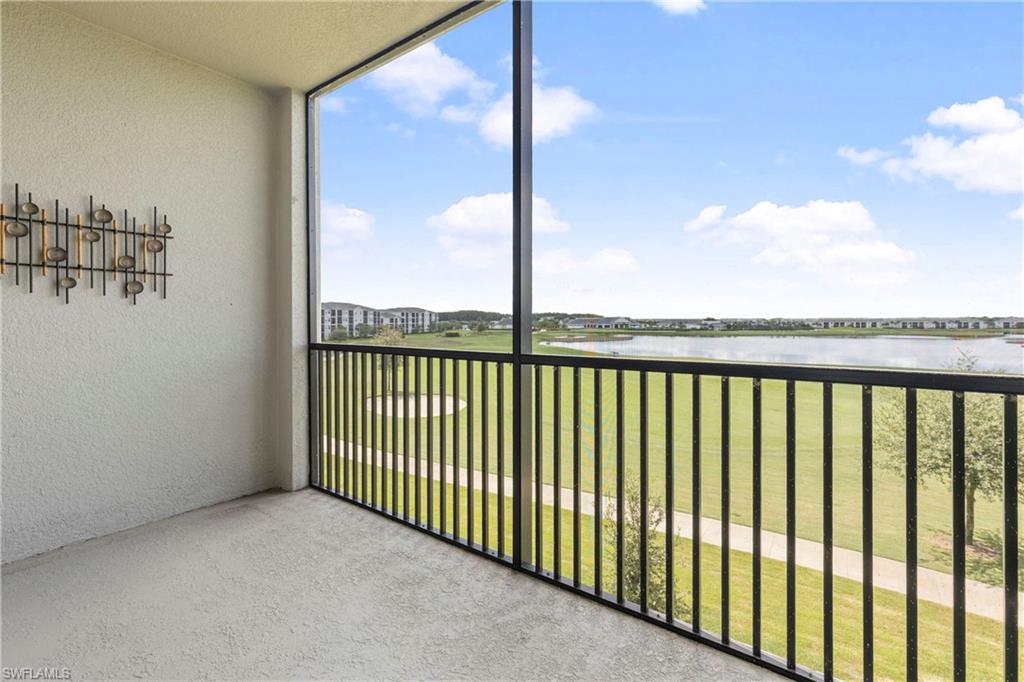 Balcony featuring a sunroom, a water view, and golf course view