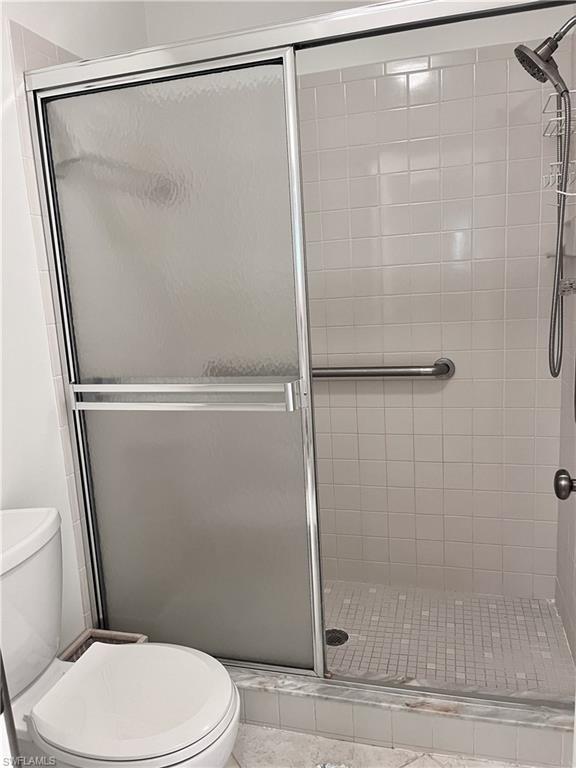 Bathroom featuring an enclosed shower and toilet