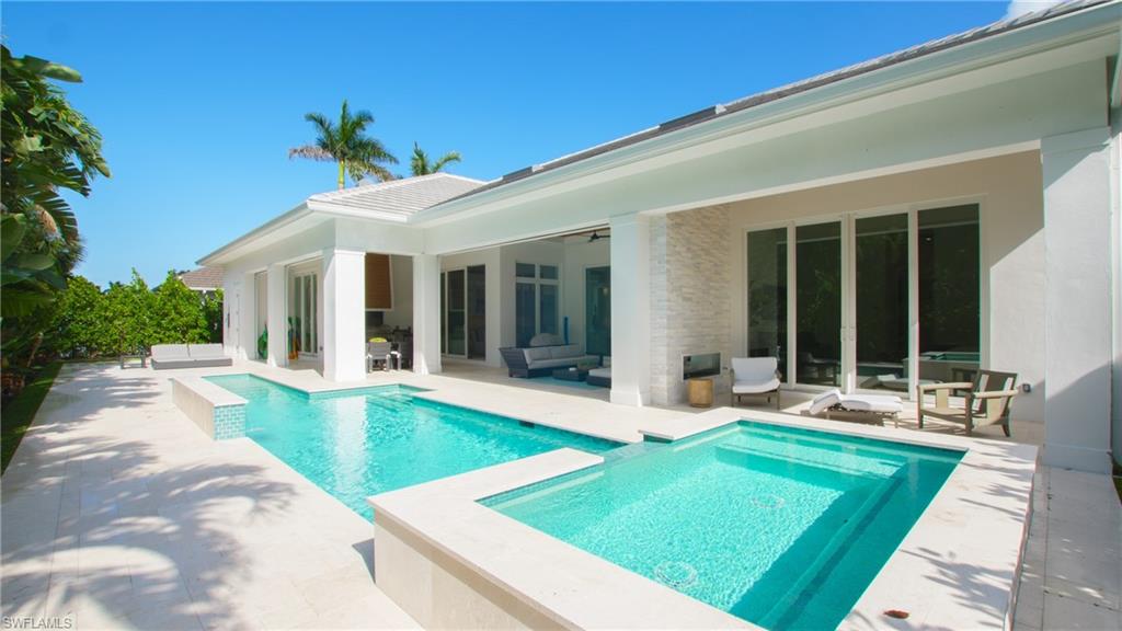 View of swimming pool with an in ground hot tub and a patio area