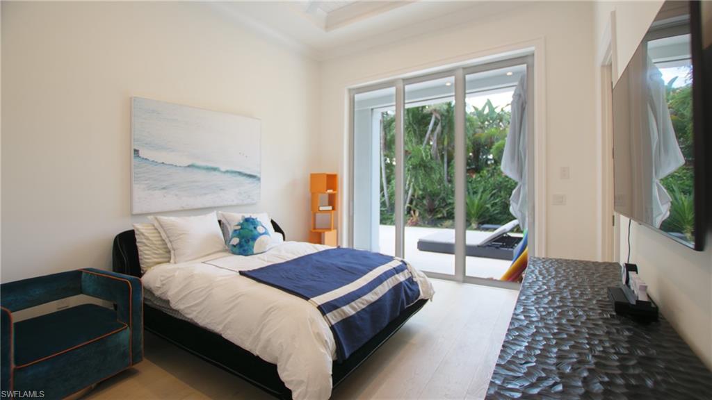 Bedroom featuring multiple windows, access to outside, and light hardwood / wood-style floors