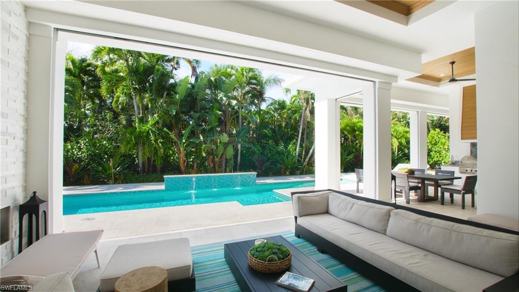 View of pool featuring pool water feature, a patio, outdoor lounge area, and ceiling fan