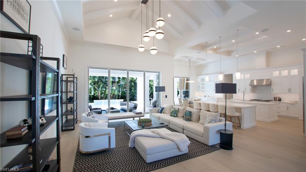 Living room with light hardwood / wood-style floors and a high ceiling
