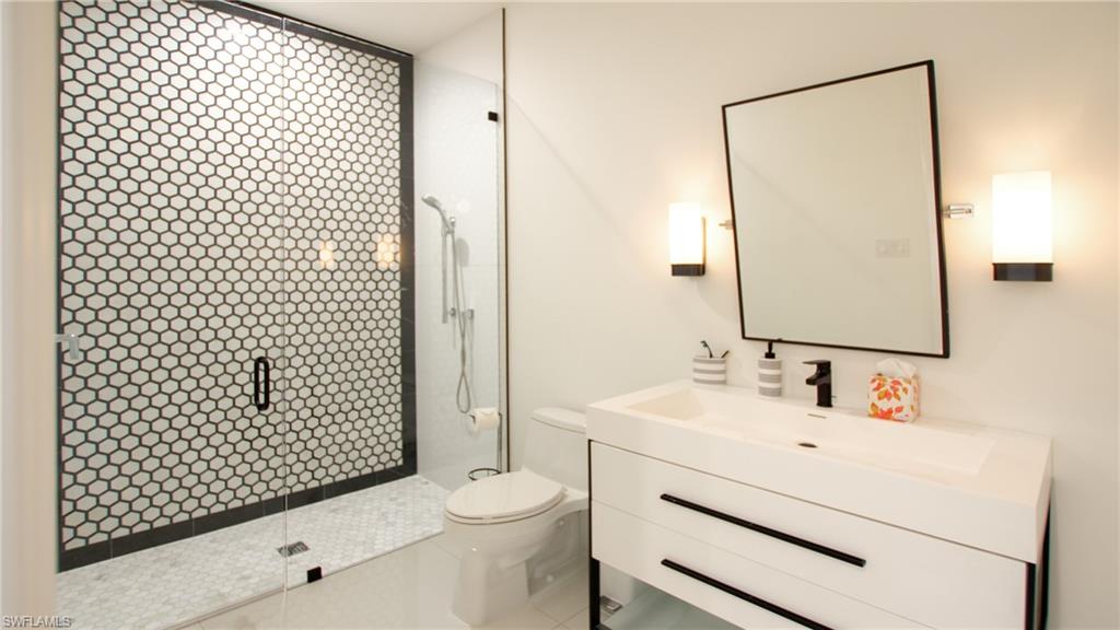 Bathroom with vanity, toilet, and a tile shower