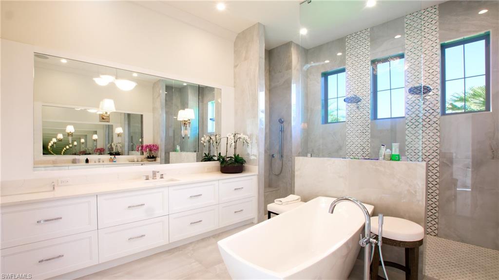 Bathroom with vanity, plus walk in shower, tile walls, and tile patterned floors