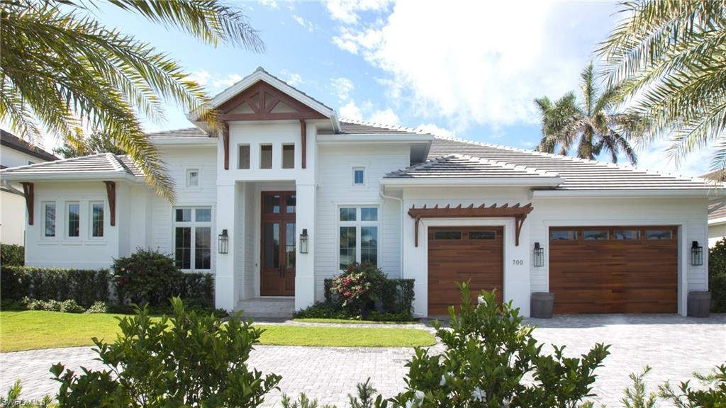 View of front of property with a garage and a front lawn