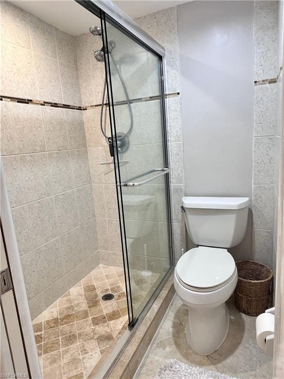 Bathroom featuring a shower stall and light tile patterned floors