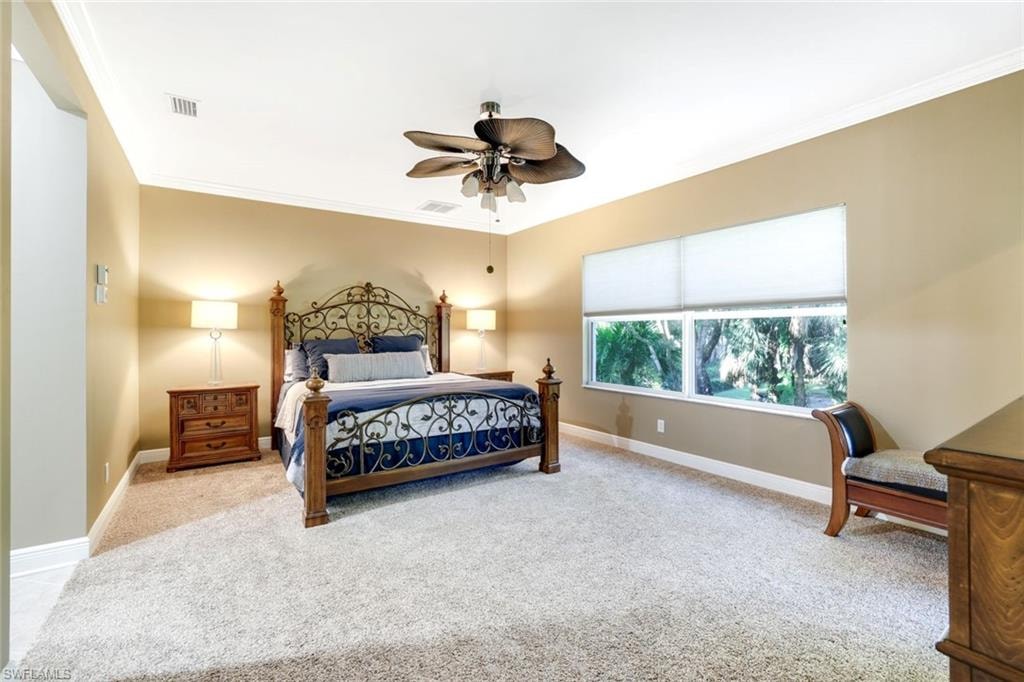 Bedroom featuring ornamental molding, carpet, and ceiling fan