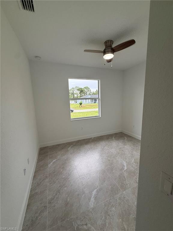 Unfurnished room with a ceiling fan and a textured wall