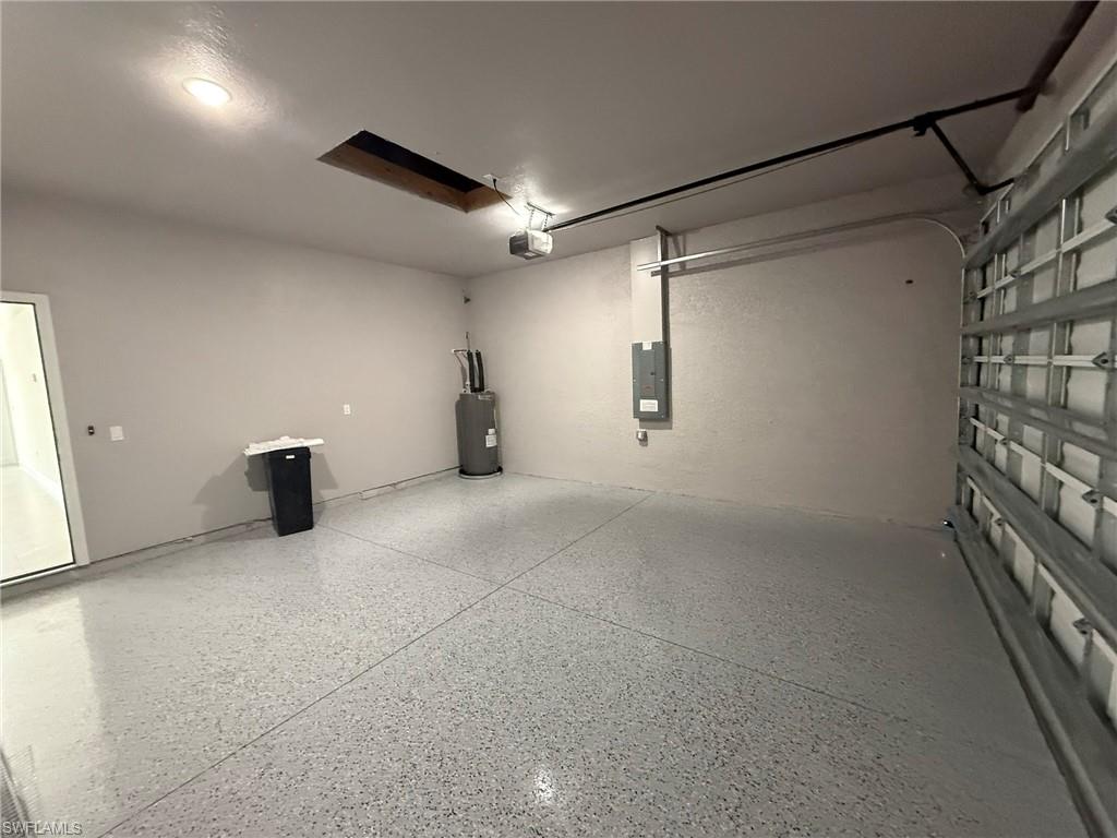 Garage featuring water heater and electric panel