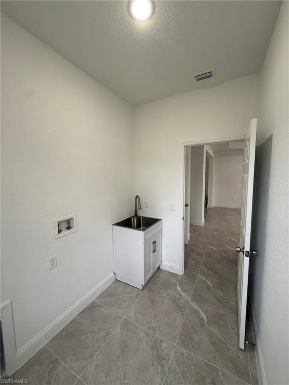 Laundry room with a textured ceiling and hookup for a washing machine