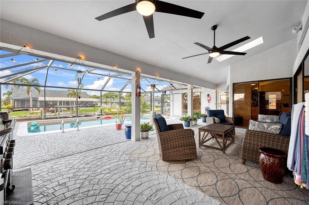View of patio featuring a lanai, a sunroom, an outdoor pool, and a ceiling fan
