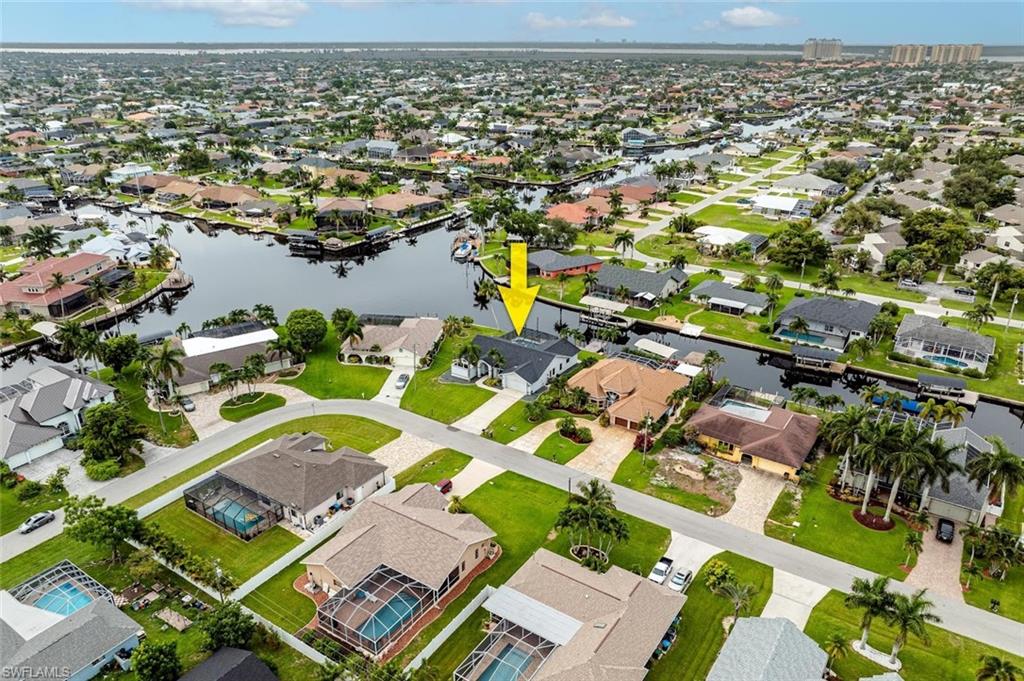 Aerial view of property and surrounding area featuring nearby suburban area