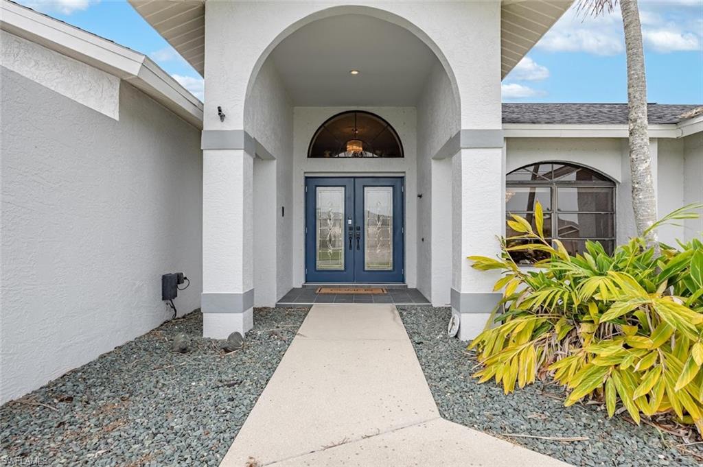 Entrance to property featuring stucco siding and french doors