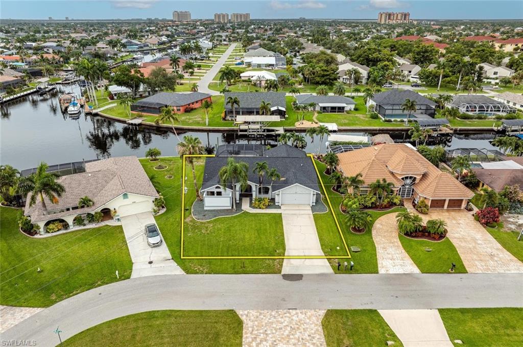 Aerial perspective of suburban area featuring a nearby body of water