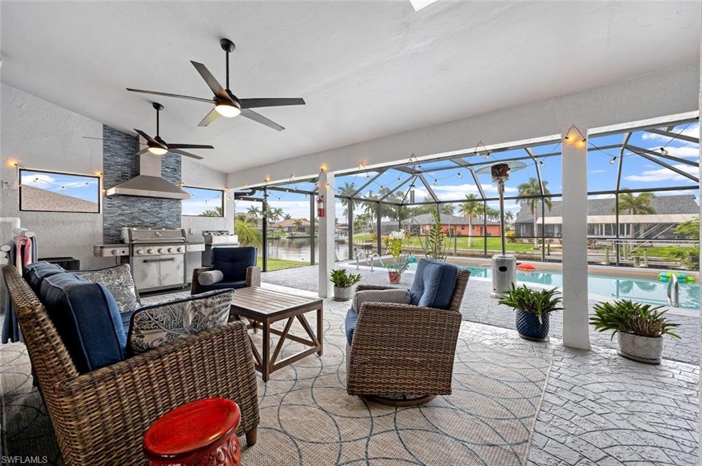 View of patio featuring a lanai, a sunroom, ceiling fan, an outdoor pool, and an outdoor hangout area