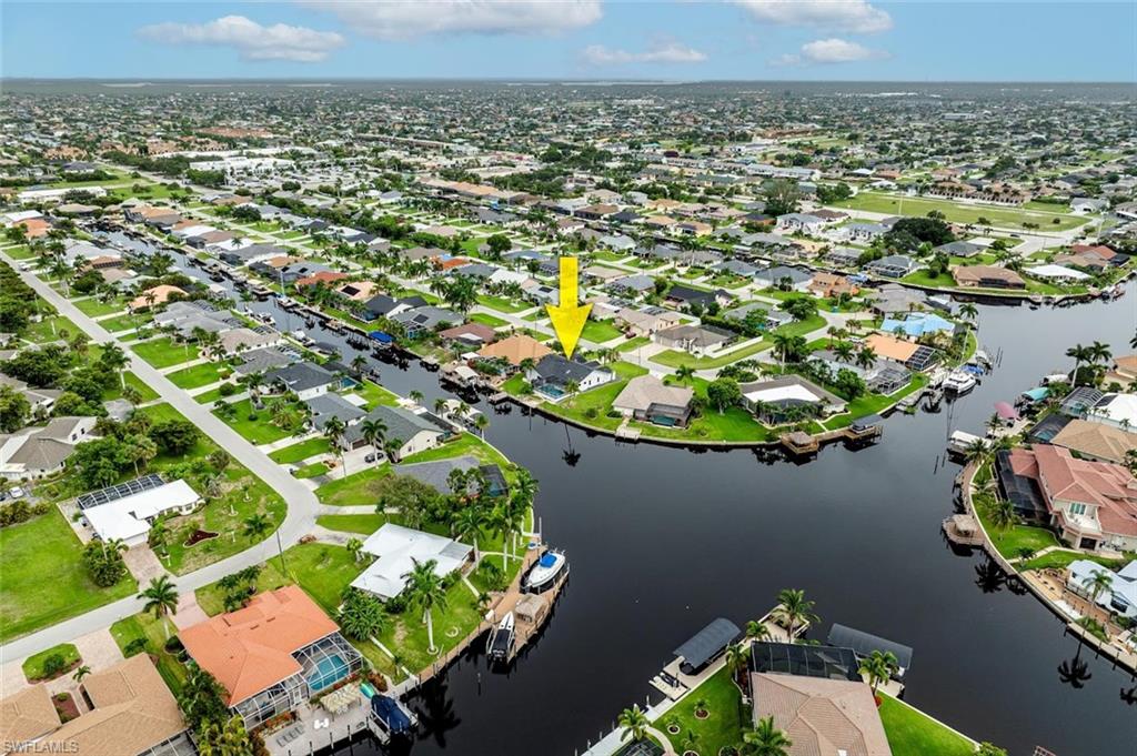 Aerial view of property and surrounding area featuring nearby suburban area and a nearby body of water