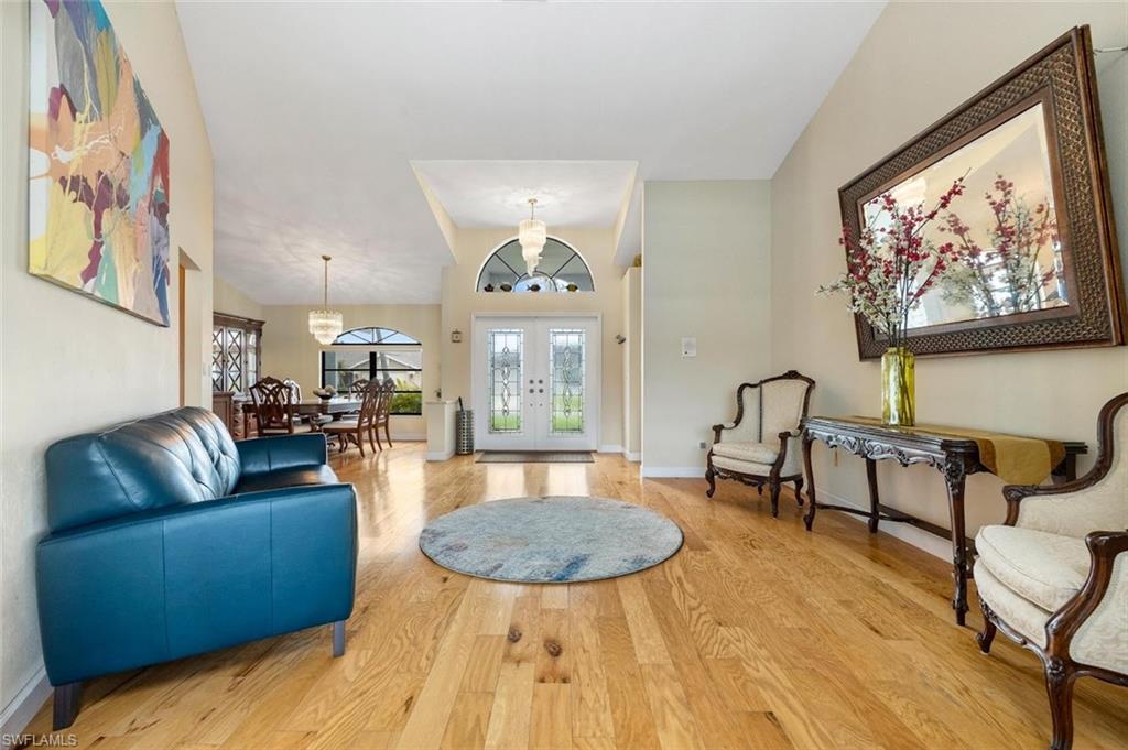 Entryway with french doors, light wood-style floors, and a chandelier