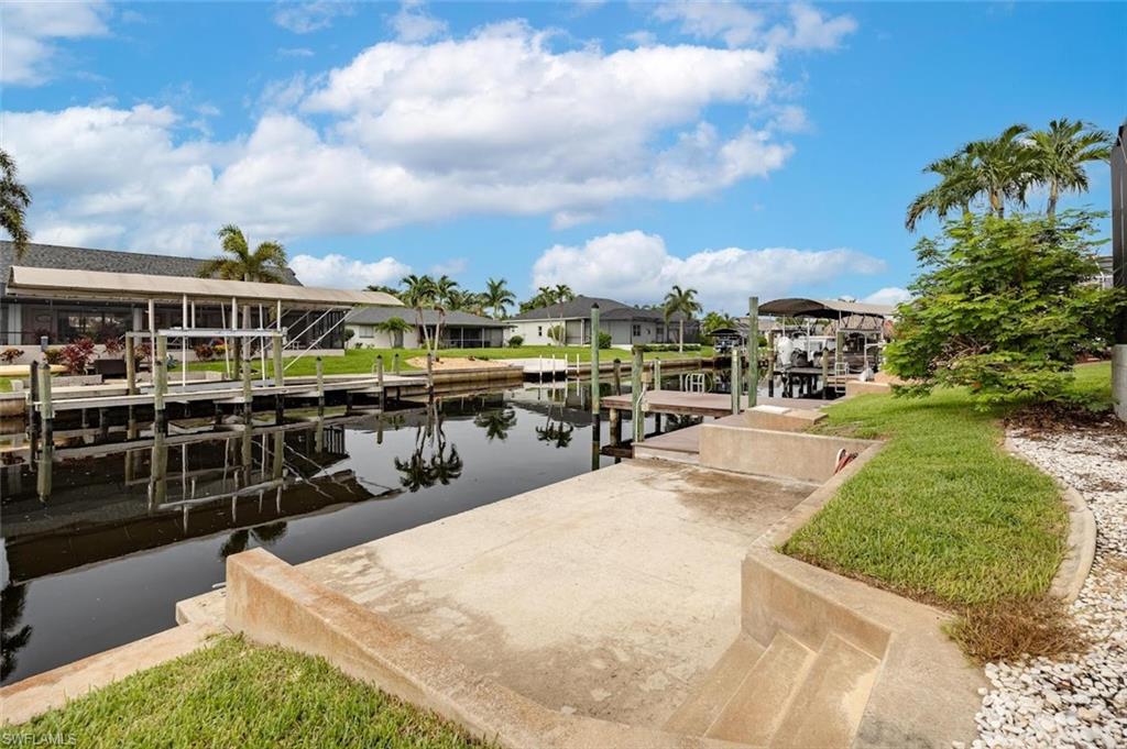 Dock area featuring boat lift, a water view, and a residential view