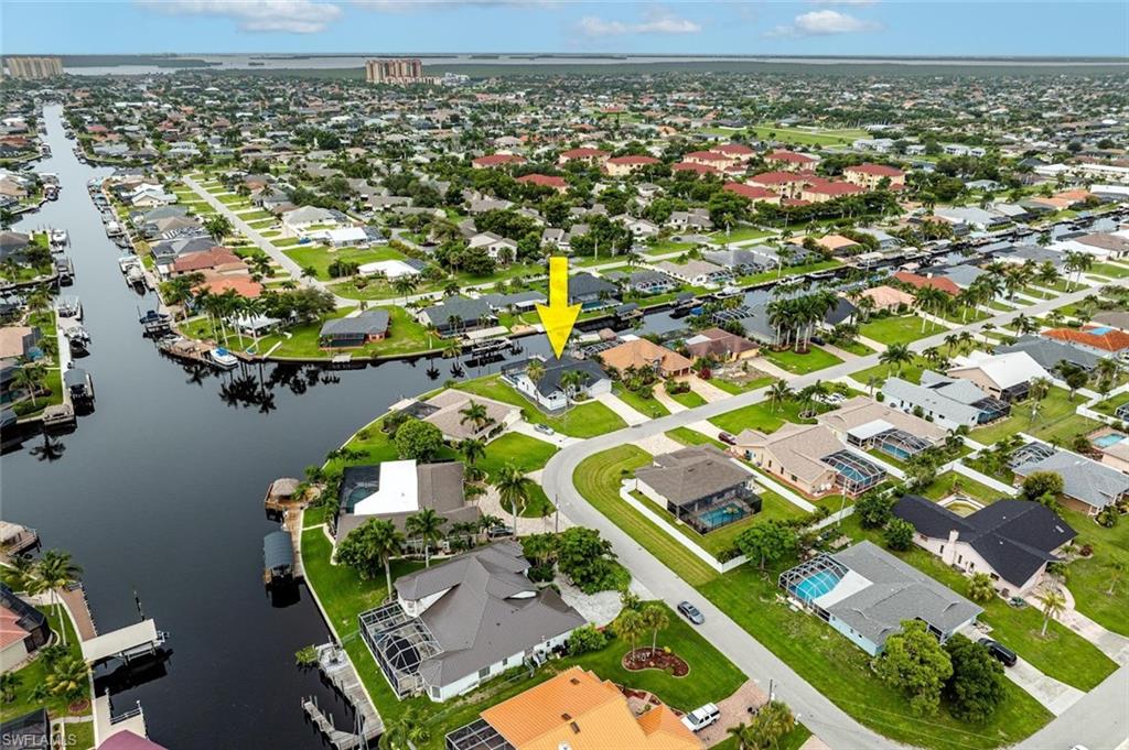 Aerial view of property and surrounding area with nearby suburban area and a large body of water