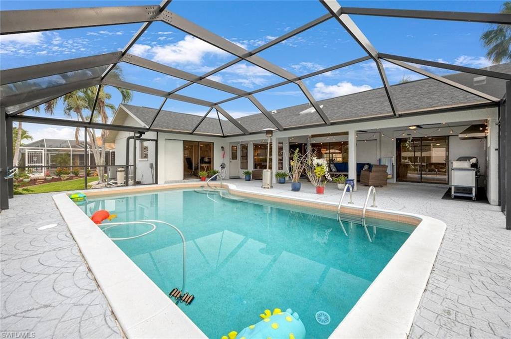 Swimming pool featuring glass enclosure, ceiling fan, a sunroom, and a patio