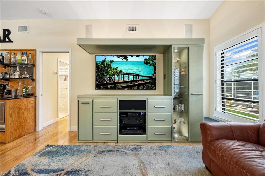 Living room featuring light wood-type flooring and bar area