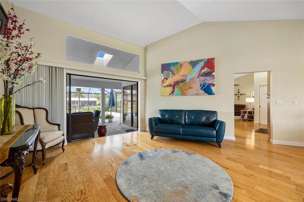 Living area featuring wood finished floors and high vaulted ceiling