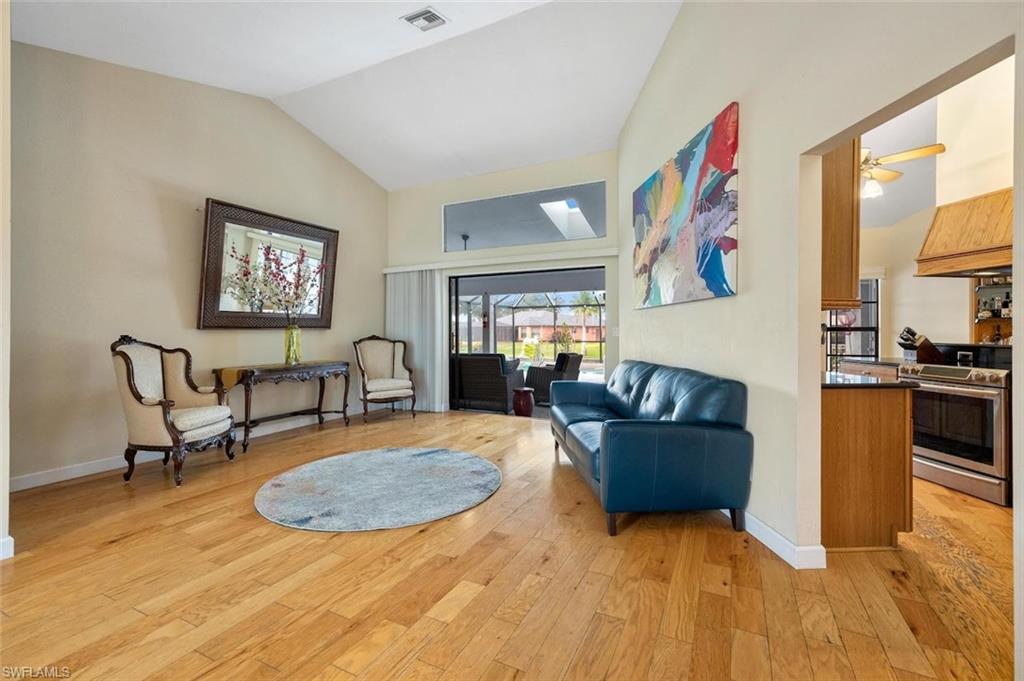 Sitting room with light wood-style floors and vaulted ceiling
