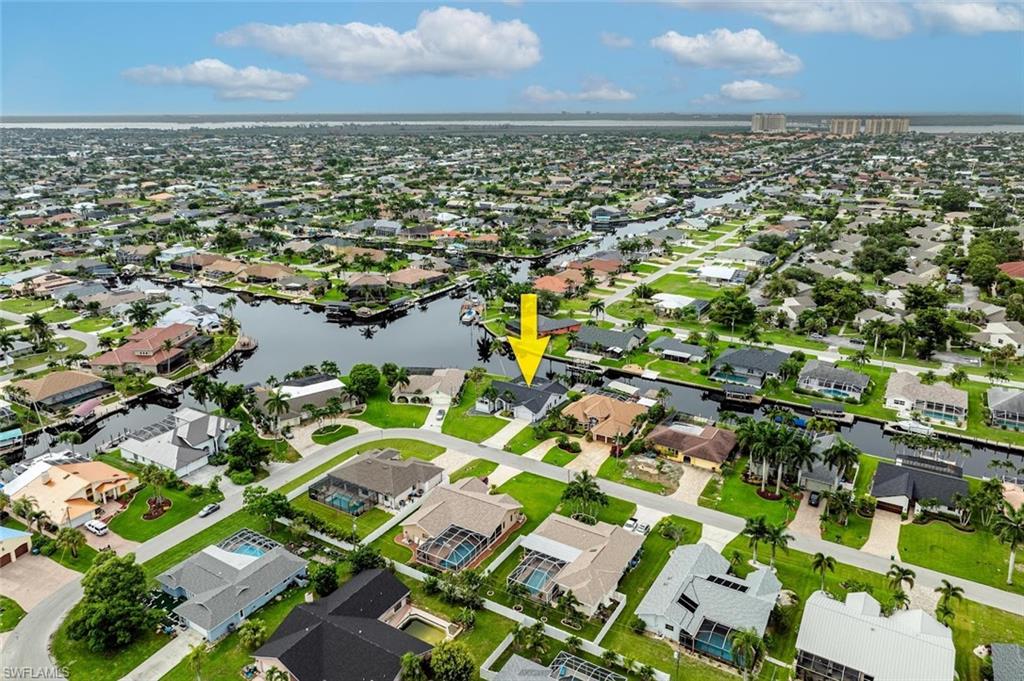 Aerial view of property and surrounding area with a large body of water and nearby suburban area