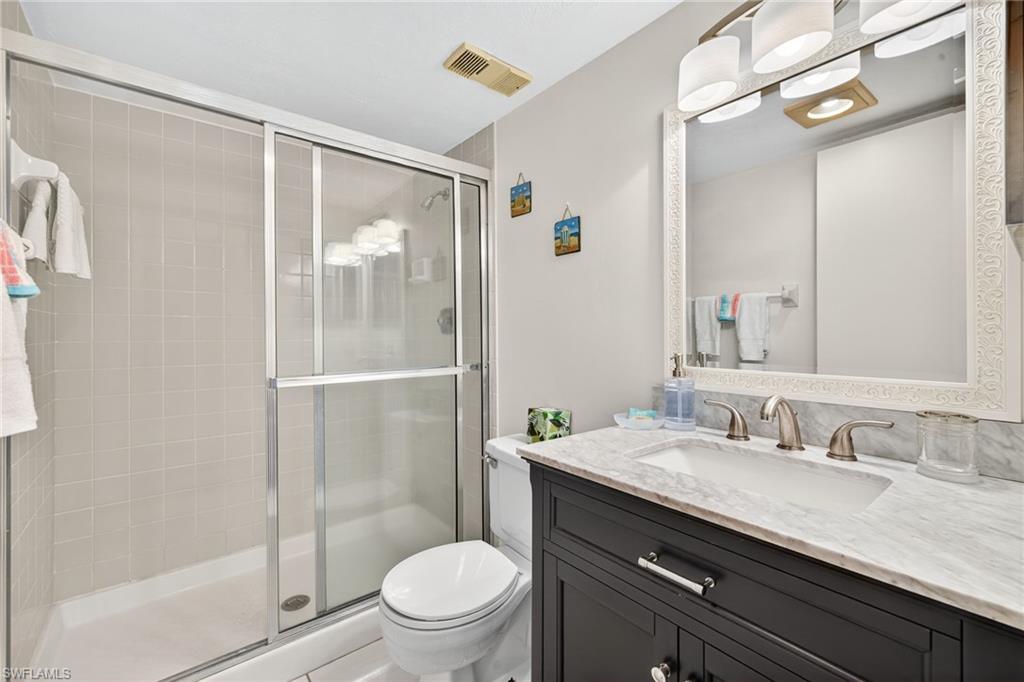 Full bath featuring a shower stall and vanity