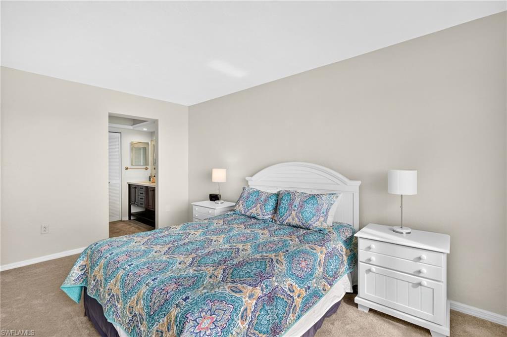 Bedroom featuring light carpet and ensuite bath