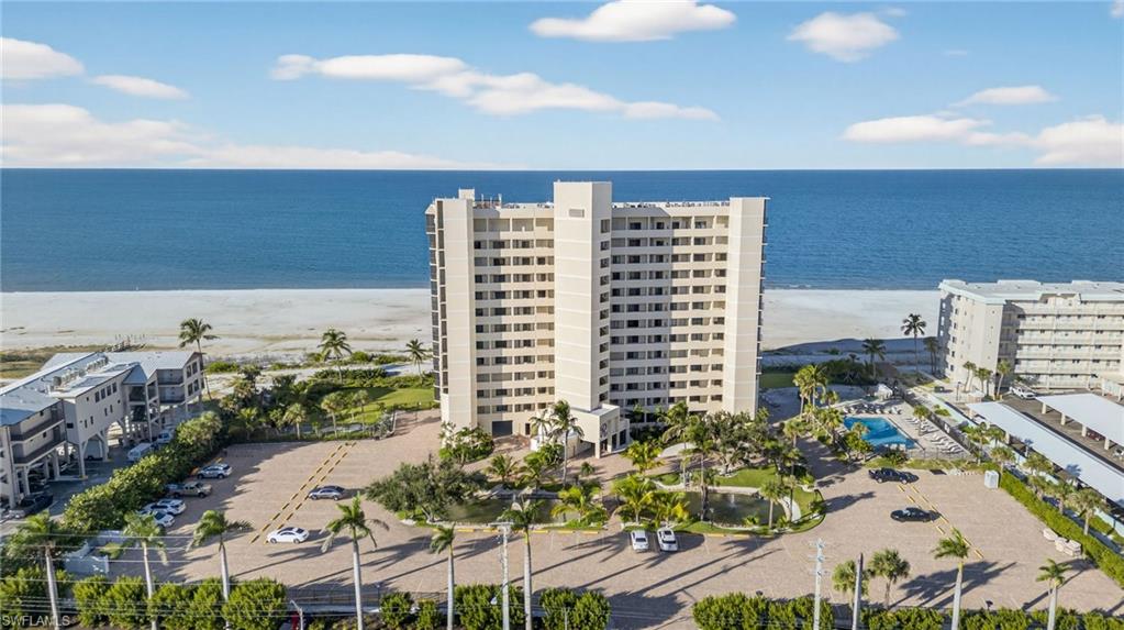 View of apartment building / complex with view of water and beach