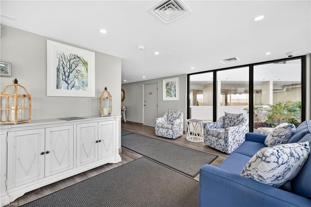 Sunroom with expansive windows, a water view, tile patterned floors, and a textured ceiling