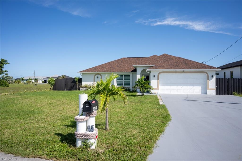 View of front of house with stucco siding, concrete driveway, an attached garage, and a shingled roof