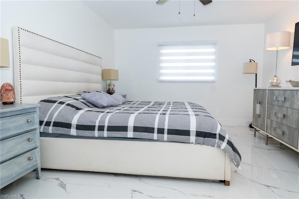Bedroom with porcelain finish floors and ceiling fan