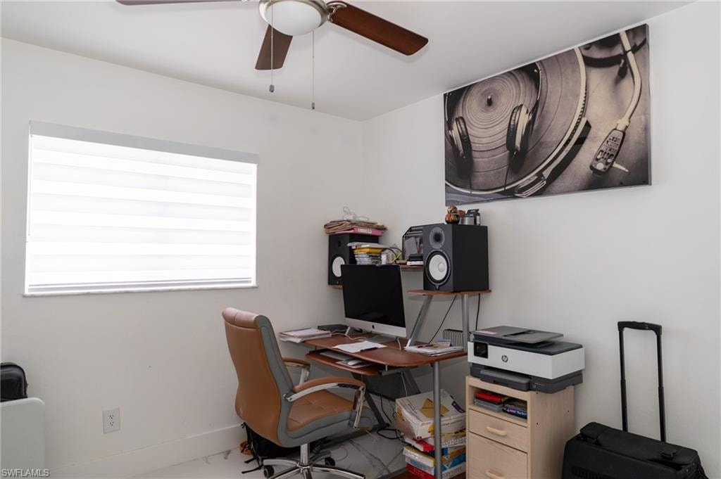 Office area with ceiling fan and baseboards