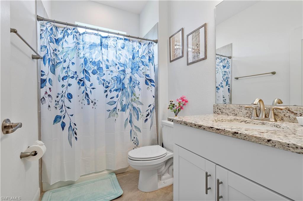 Bathroom with tile patterned flooring, vanity, toilet, and a shower with shower curtain