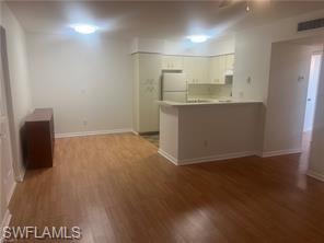 Empty room with dark wood finished floors and a ceiling fan